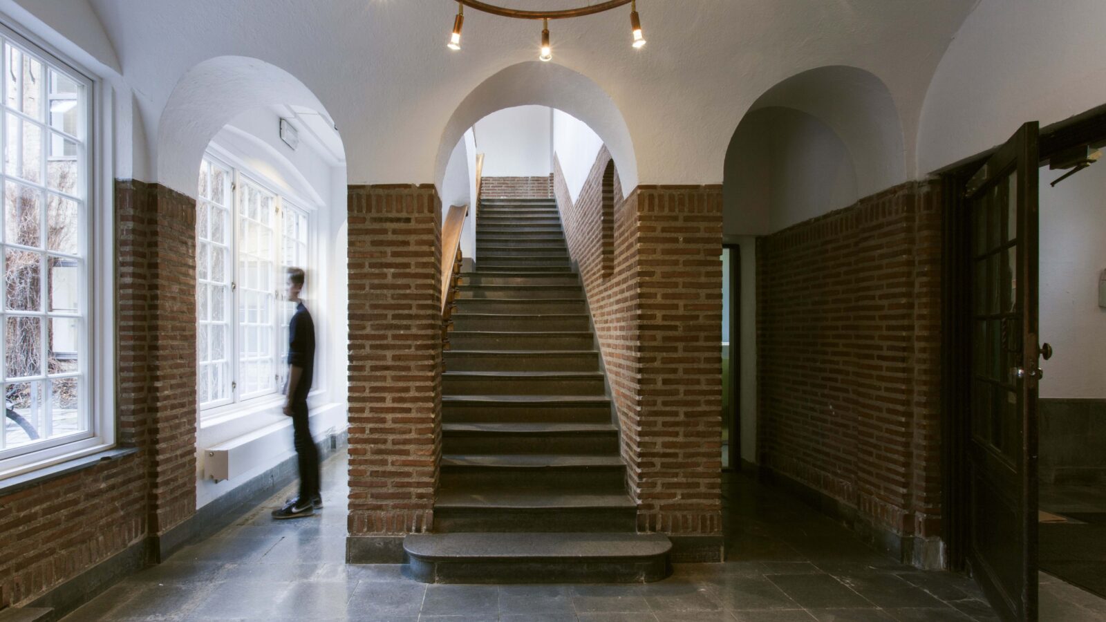 Murhus innvendig, stor trapp og buede tak.