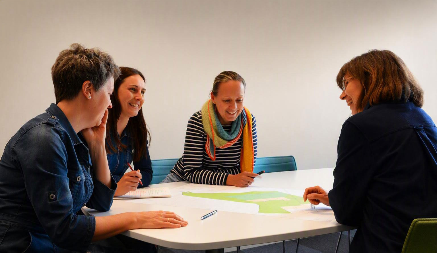 4 rådgivere ved kontor Kongsberg som sitter rundt et bord og ser på en tegning.