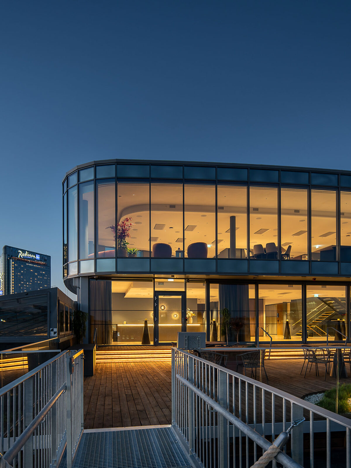 Sixa med de to øverste etasjene sett fra utsiden hvor vi ser eksteriøret med vinduer fra gulv til tak og en stor terrasse foran.