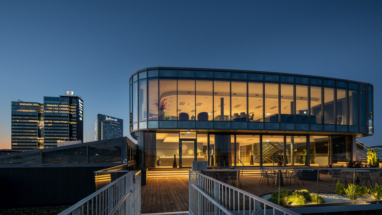 Sixa med de to øverste etasjene sett fra utsiden hvor vi ser eksteriøret med vinduer fra gulv til tak og en stor terrasse foran.