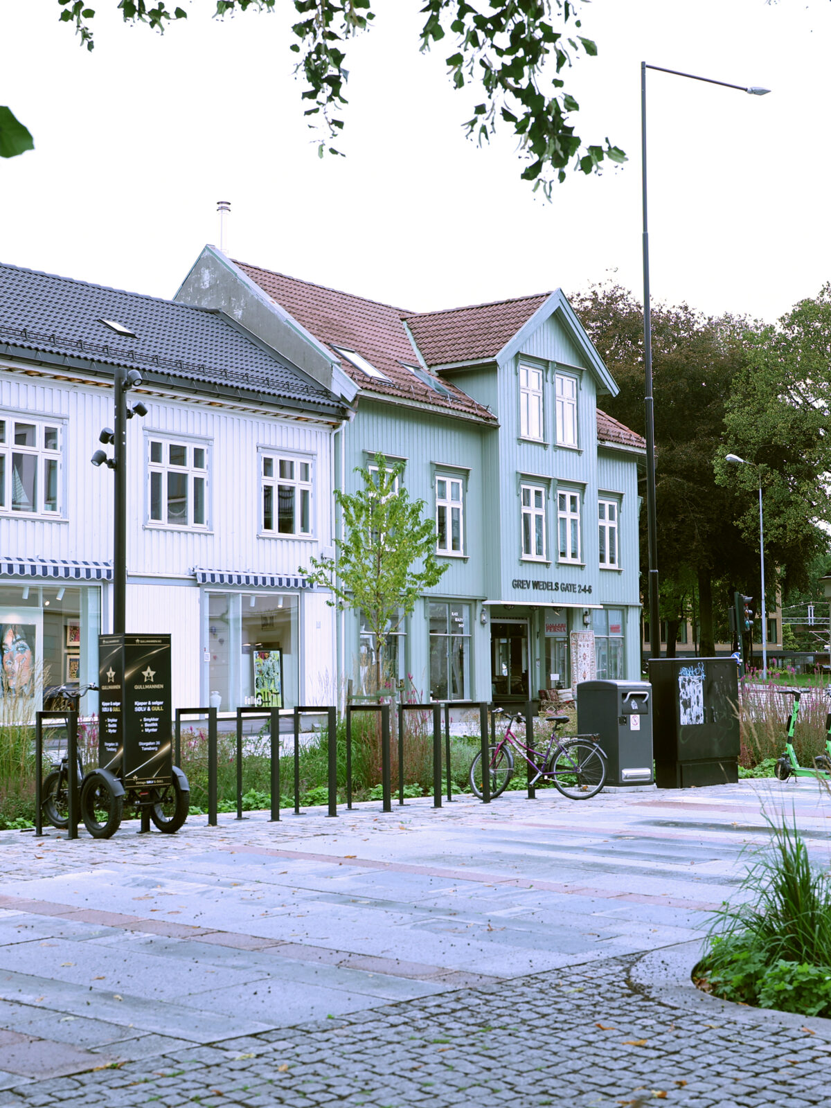 Oversiktsbilde over Farmannstorvet i Tønsberg sentrum med tilrettelegging for myke trafikanter med universell utforming, grønne oppholdsarealer og sykkelstativ.