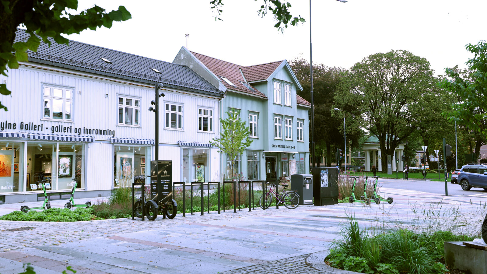 Oversiktsbilde over Farmannstorvet i Tønsberg sentrum med tilrettelegging for myke trafikanter med universell utforming, grønne oppholdsarealer og sykkelstativ.