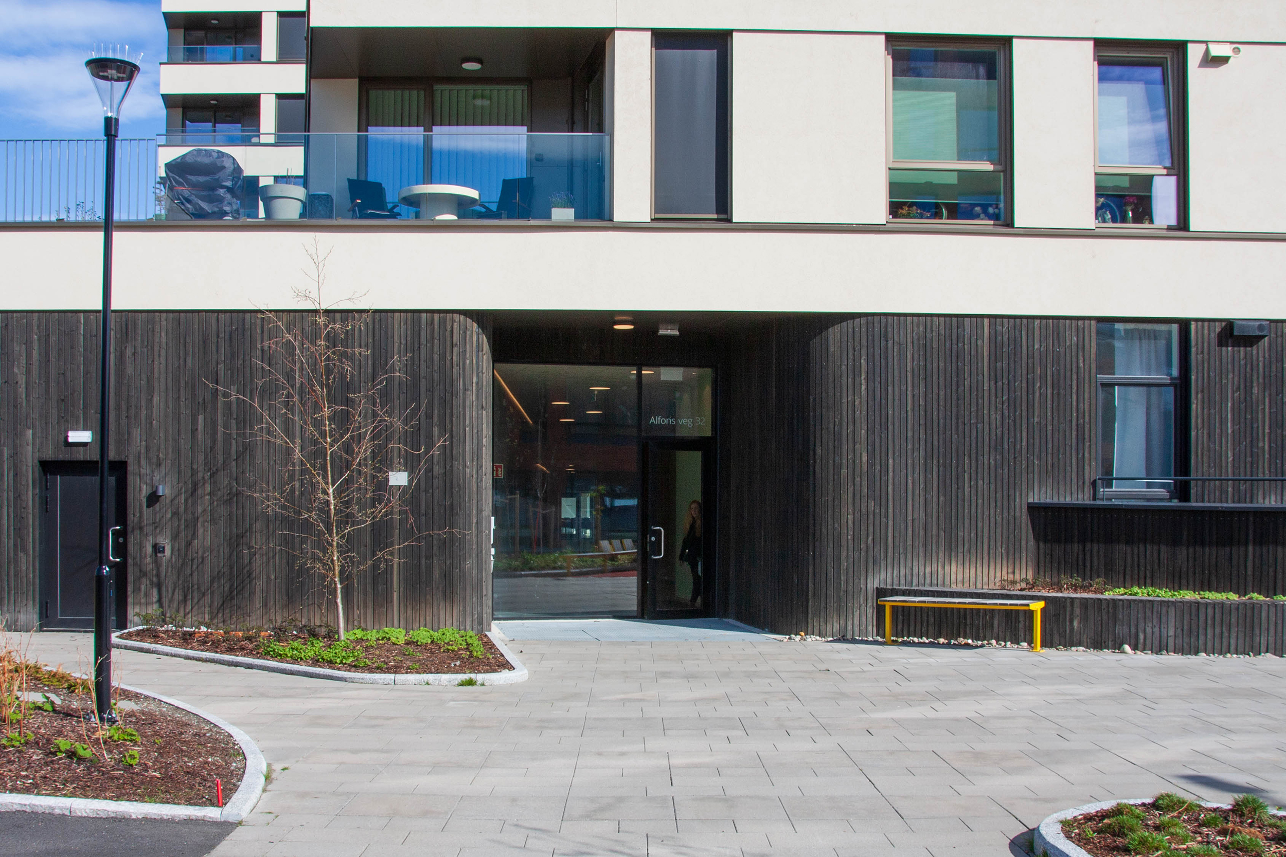 Inngangspartiet til Alfon B har mørkt tre, glassdør og et romslig uteområde.