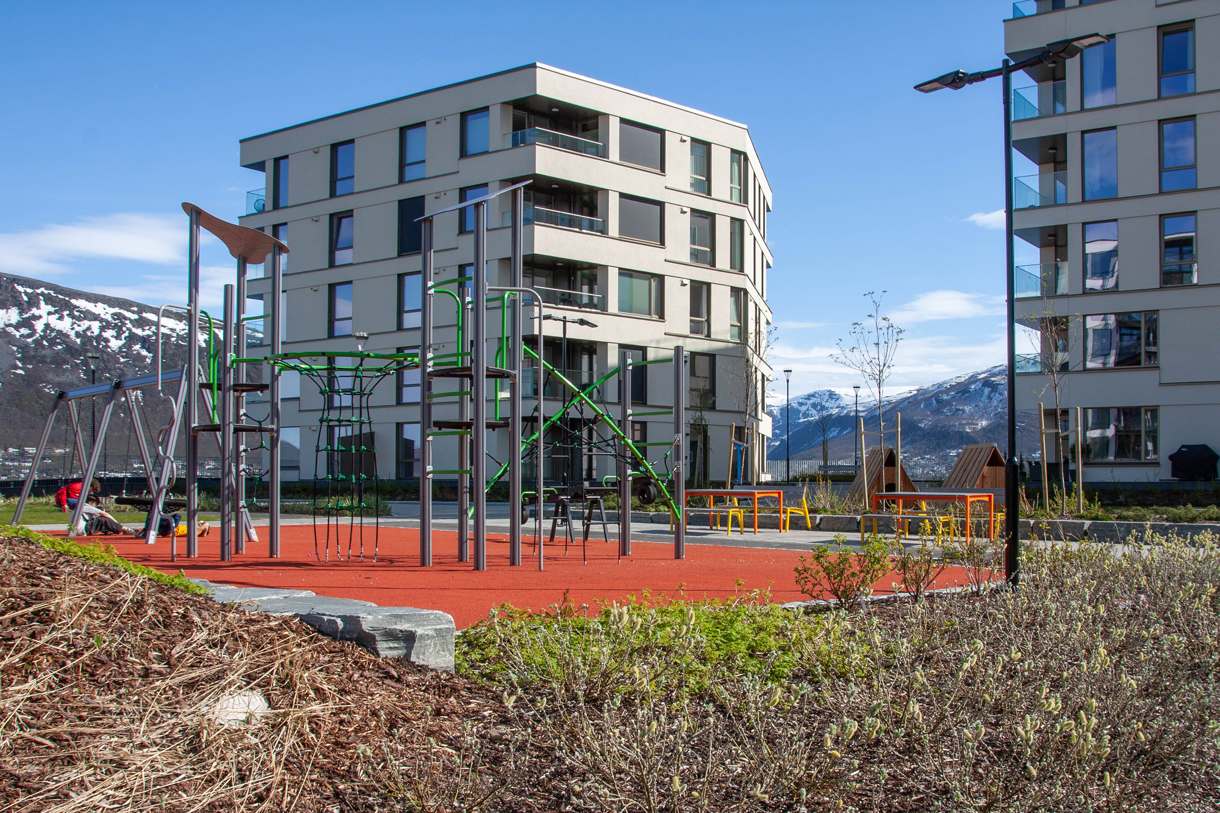 Lekeplassen mellom Alfon B og C har apparater på dempet underlag, grøntområde og utsikt mot fjellene.