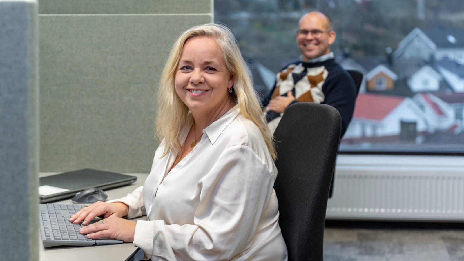 Inger Synnøve Elsness (fagsjef landskapsarkitektur) og Martin Rustan Aas (gruppeleder og fagsjef VVS) i bakgrunnen på Asplan Viak sitt kontor i Tønsberg.