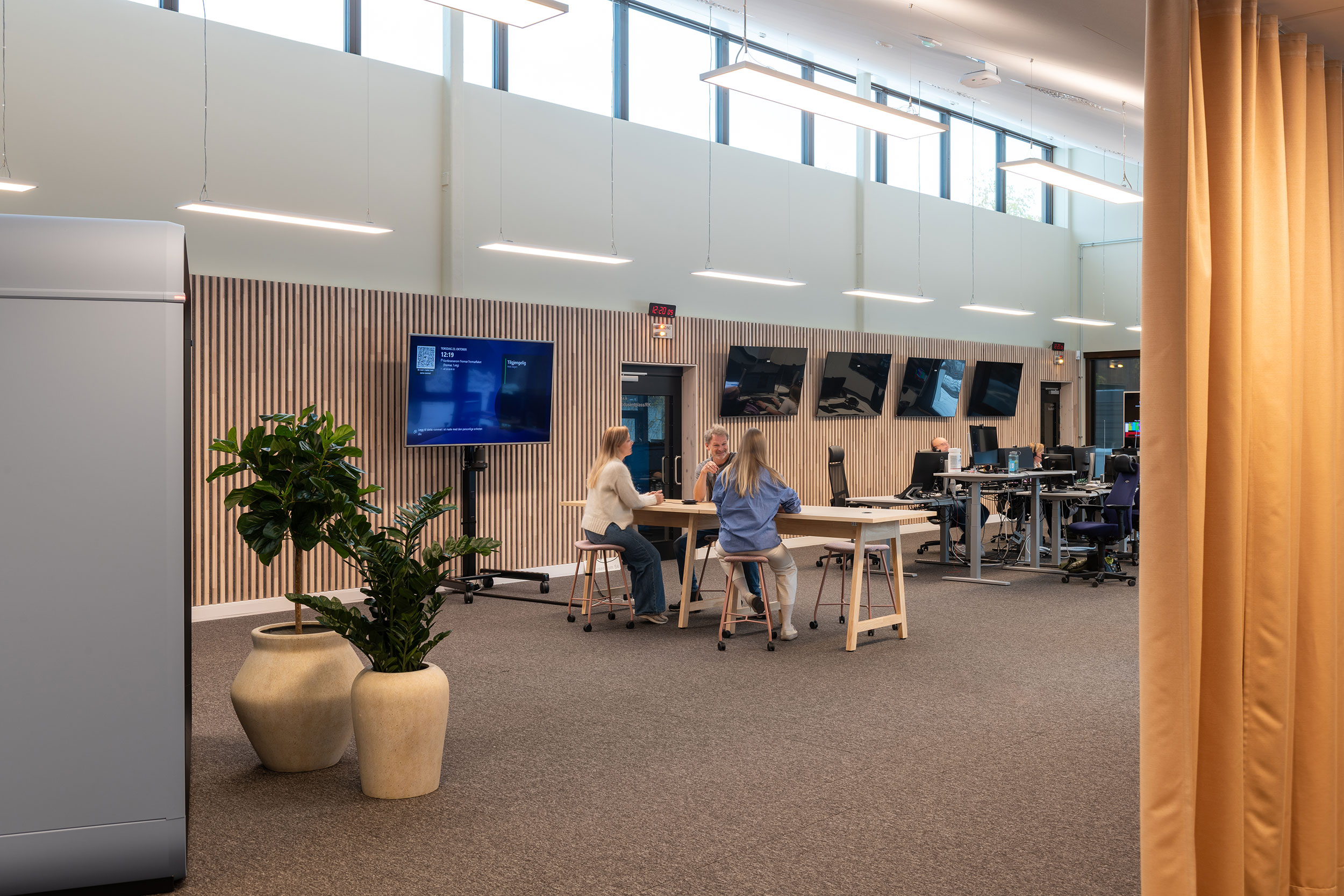 Interiørbilder av NRK Tromsø, lokalene til redaksjonen med fellesbord og arbeidsplasser.