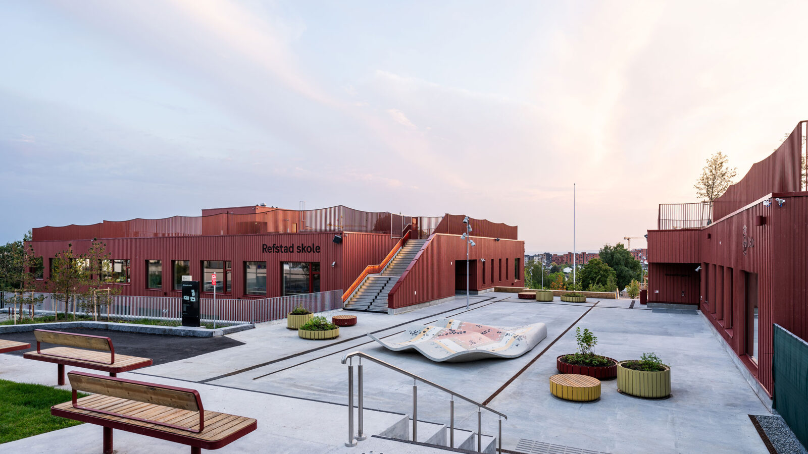 Bilde av skolegård og eksteriør på Refstad skole.