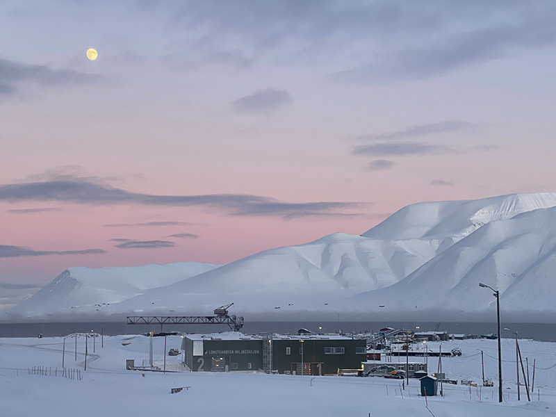 Rosa himmel over snøkledde Longyearbyen. Miljøstasjonen i forgrunnen.
