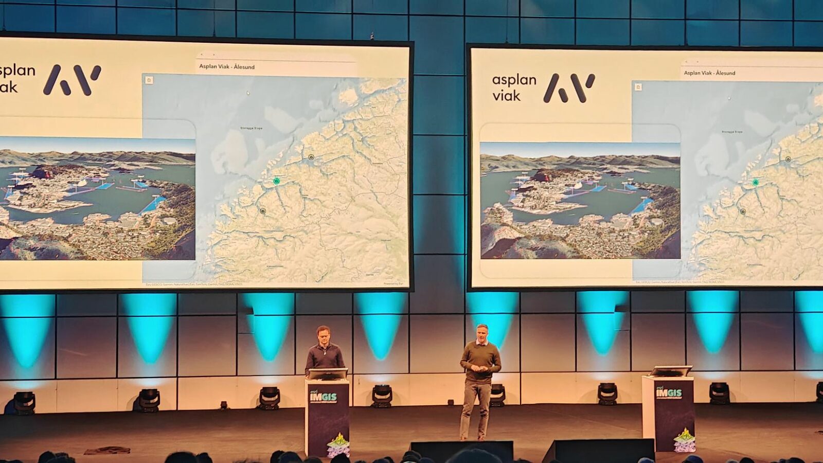To foredragsholdere på en stor scene som viser hvordan digital tvilling brukes i planlegging og byutvikling.