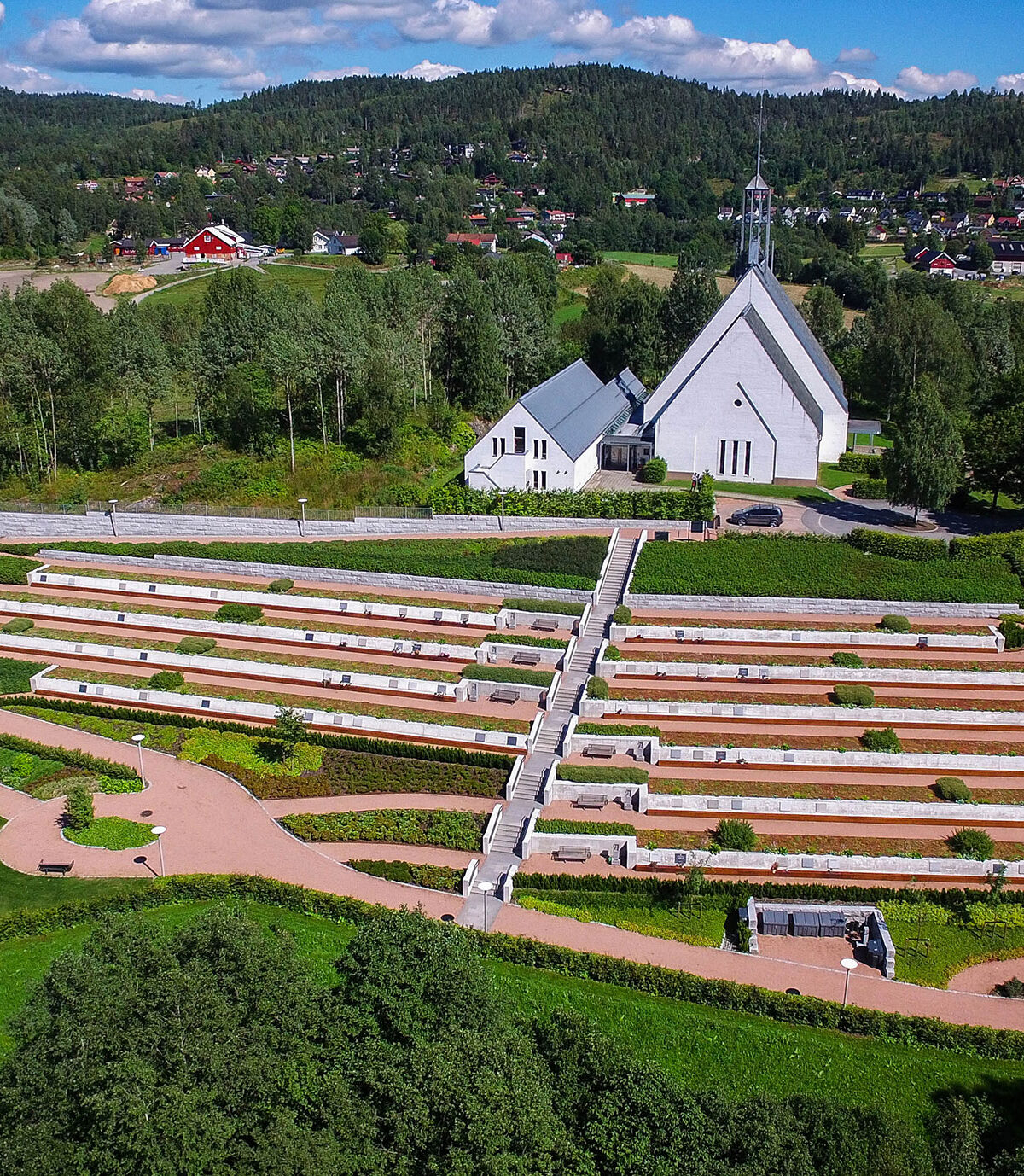 Dronebilde tatt skrått ovenfra av Lommedalen kirke og gravlund