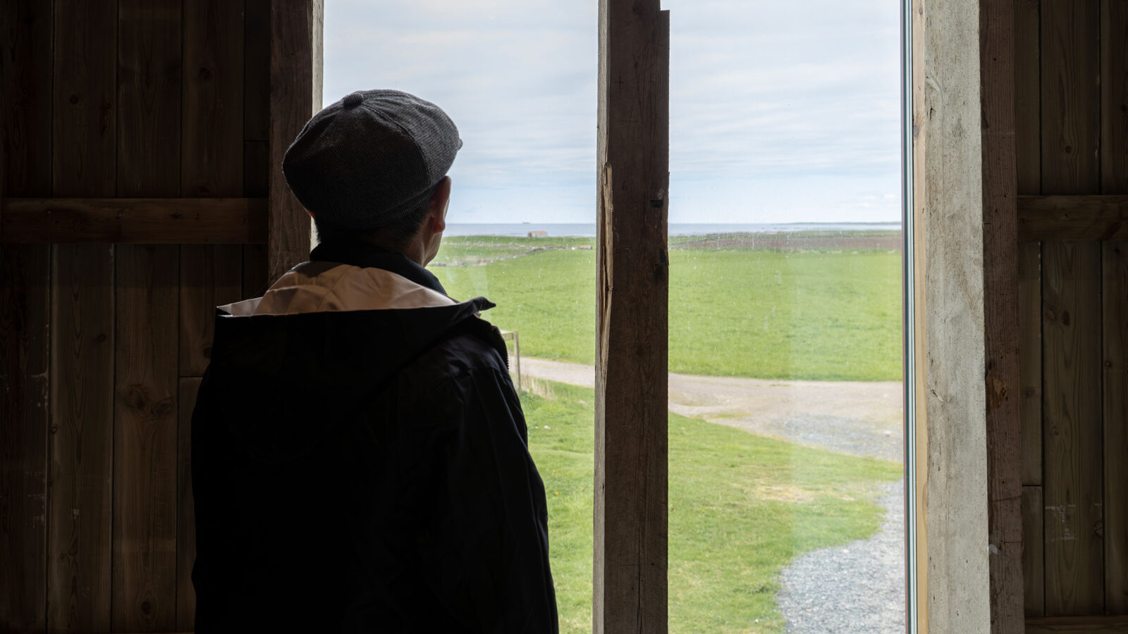 En person som ser ut gjennom glassveggen på Nye Løa på Hå gamle prestegård