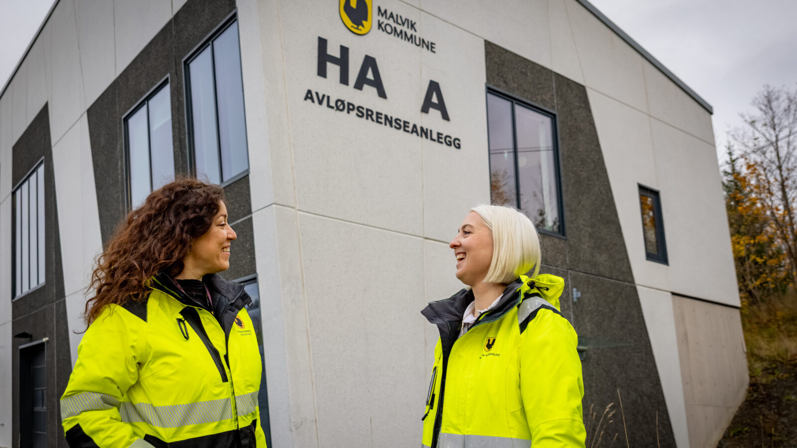 To kvinner står utenfor avløpsrenseanlegget i Malvik kommune. Begge har på seg ytterjakker som viser at de jobber i kommunen.
