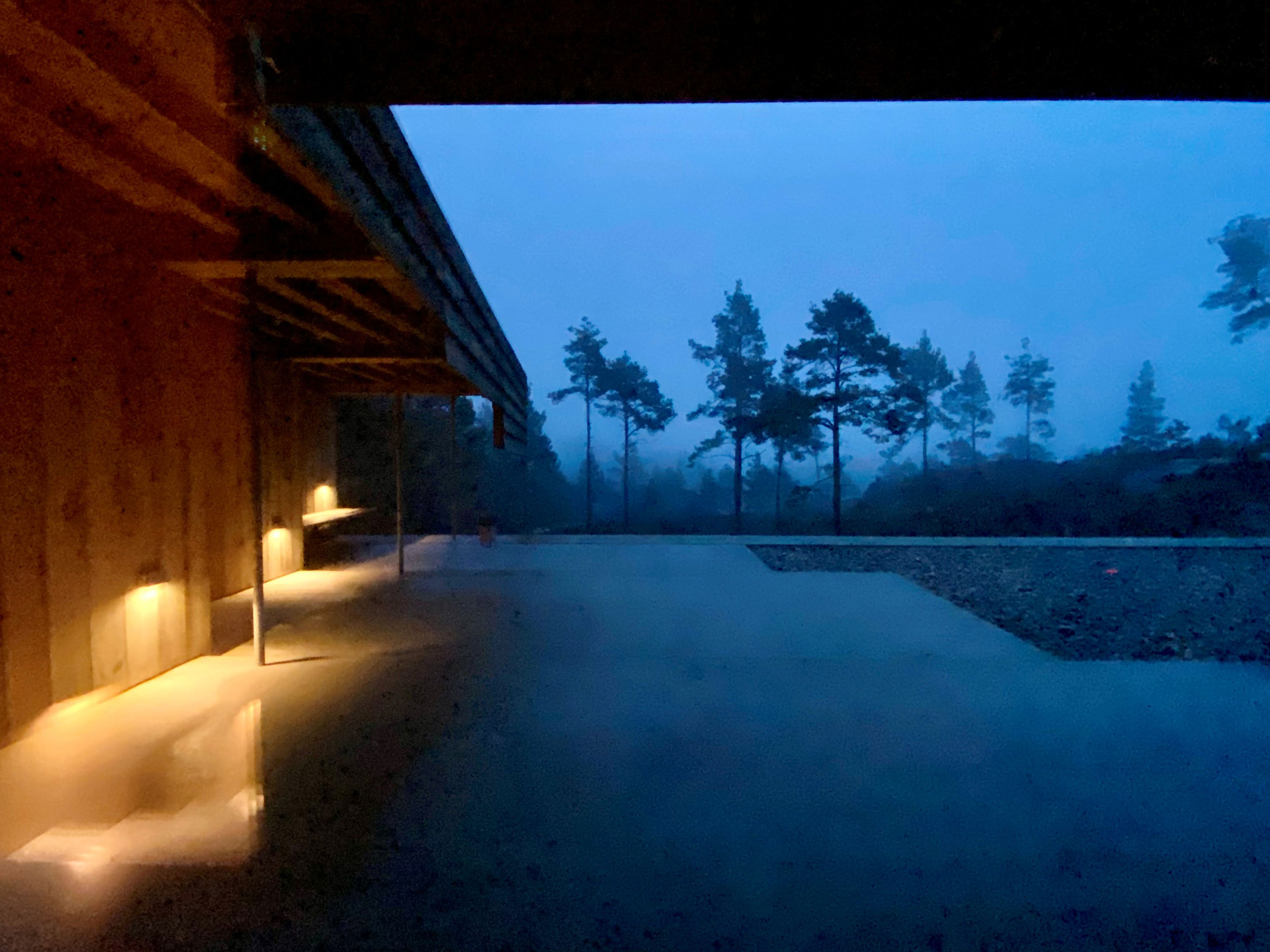 kveldsfoto av uteplass og utsikt mot trær hytte risør