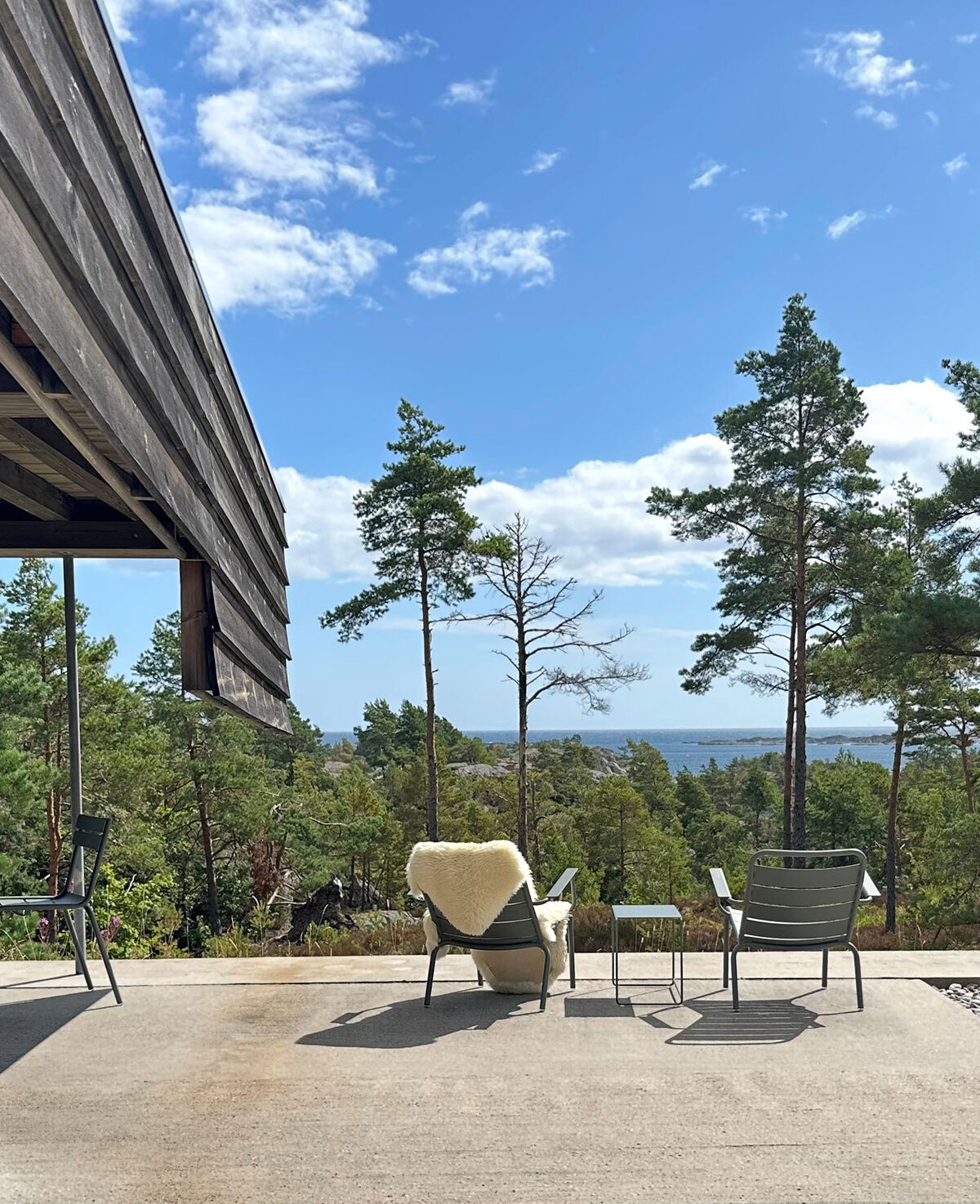 Utsikt fra uteplass og mot skog og sjø fra hytte i Risør