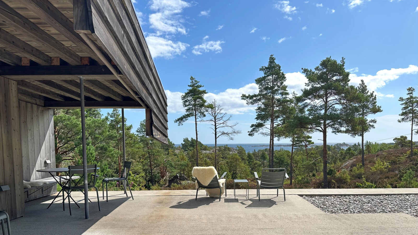 Utsikt fra uteplass og mot skog og sjø fra hytte i Risør